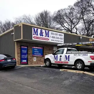 The M & M Heating & Air office building with a service truck outside.